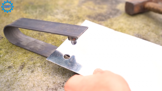 Processen med at gøre huller i metalpladen ved hjælp af en hjemmelavet instrument