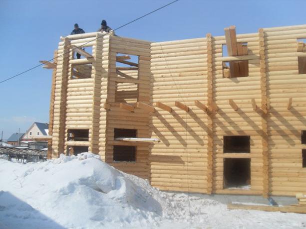 Opbygning af et hus af træ i vinteren.